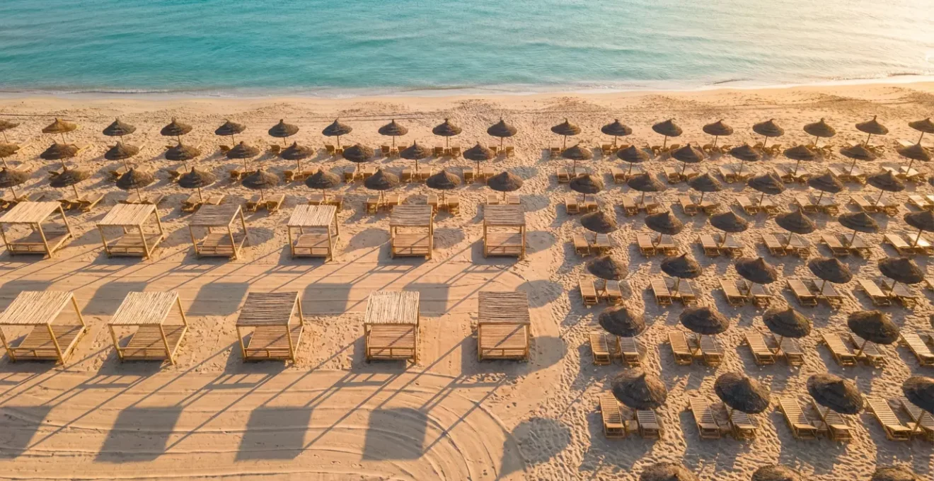 Vue aérienne d'une plage de resort montrant l'organisation des transats et les différentes zones